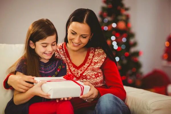 Festive mother and daughter holding christmas present — Stock Photo, Image