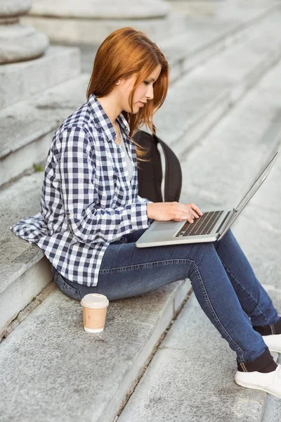 Ung student använder sin bärbara dator för att studera utanför — Stockfoto