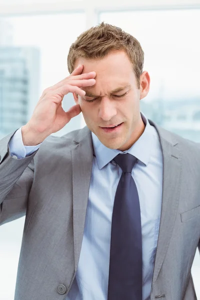 Uomo d'affari con forte mal di testa in ufficio — Foto Stock