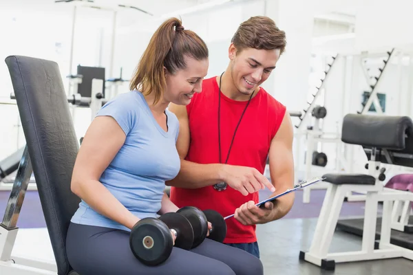 Personal trainer working with client holding dumbbell — Stock Photo, Image