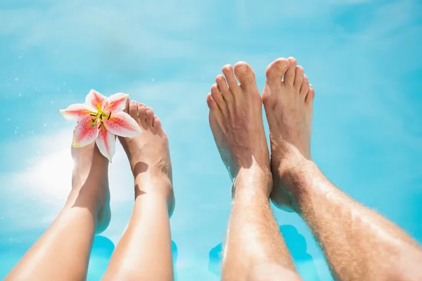 Couple feet against swimming pool on a sunny day — Stock Photo, Image