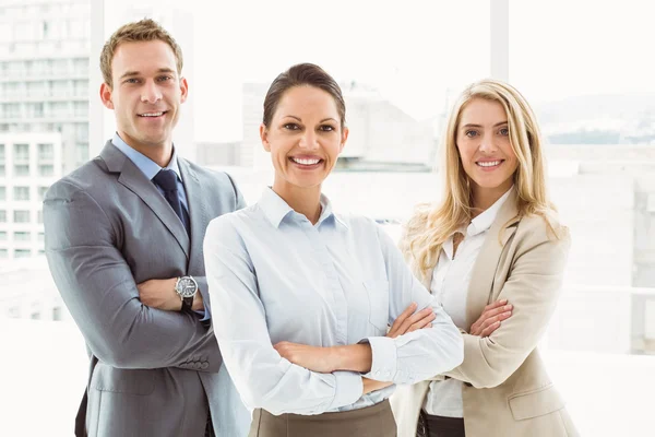 Young business people with arms crossed in office — Stock Photo, Image