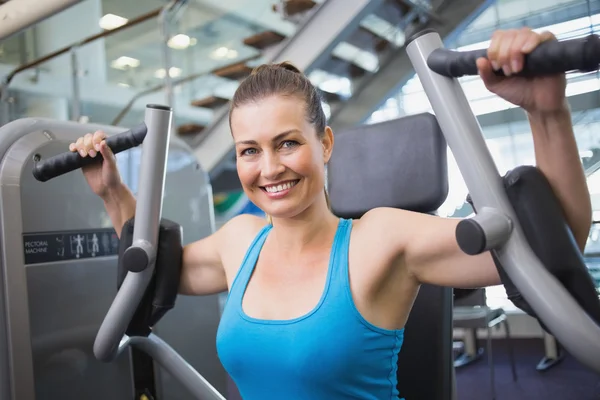 Fit brunette met behulp van gewichten machine voor wapens — Stockfoto