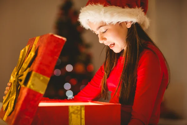 Feestelijke meisje openen een gloeiende kerstcadeau — Stockfoto