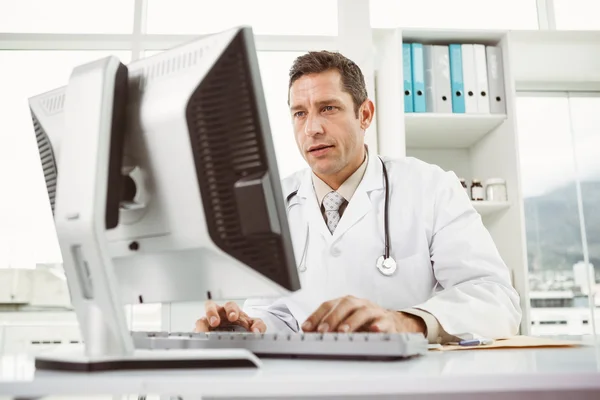 Médico usando computadora en consultorio médico — Foto de Stock