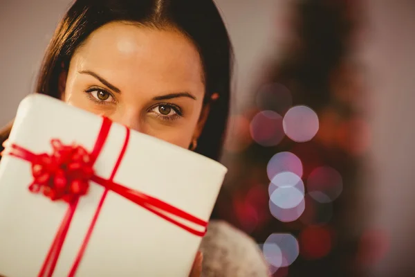 Pretty brunette holding christmas present — Stock Photo, Image