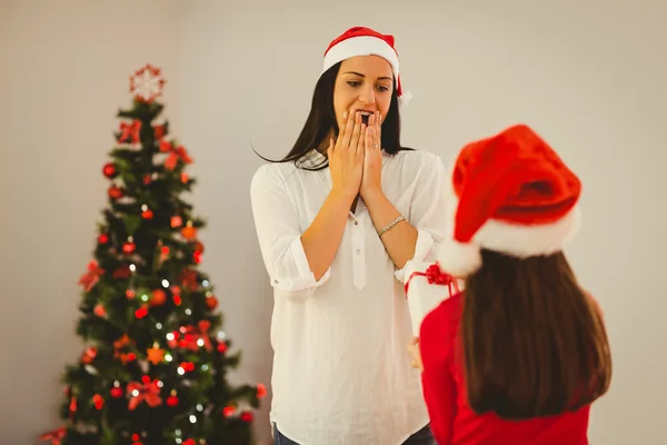 Filha surpreendendo sua mãe com presente de Natal — Fotografia de Stock