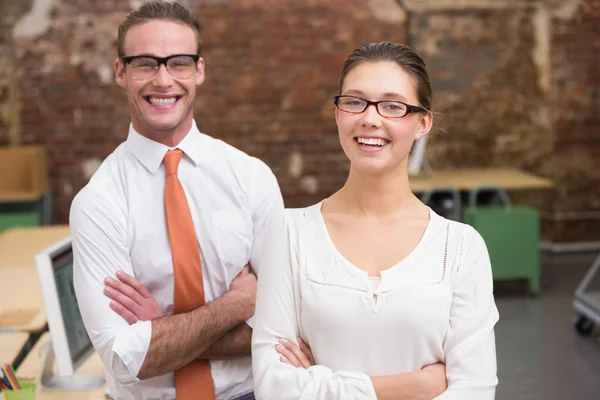 Два улыбающихся коллеги по бизнесу в офисе — стоковое фото
