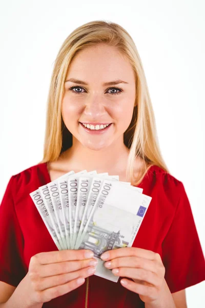 Vackra blonda i röd klänning visar hennes pengar — Stockfoto