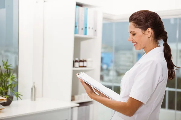 Médica segurando prancheta no consultório médico — Fotografia de Stock