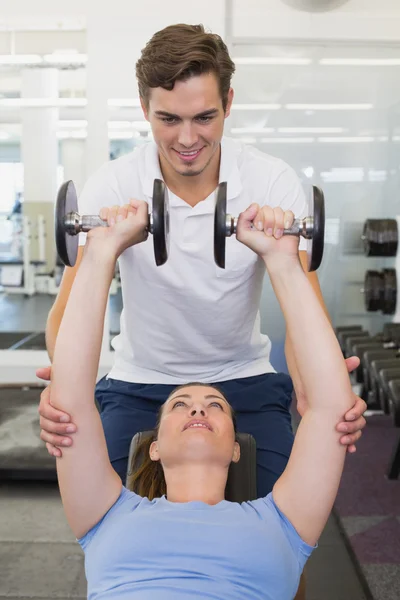 Personal trainer helping client lift dumbbells — Stock Photo, Image