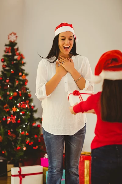 Filha surpreendendo sua mãe com presente de Natal — Fotografia de Stock