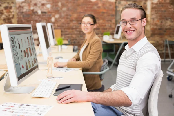 Redattori di foto sorridenti che utilizzano il computer in ufficio — Foto Stock