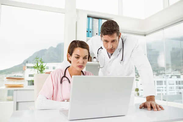 Médicos usando laptop no consultório médico — Fotografia de Stock