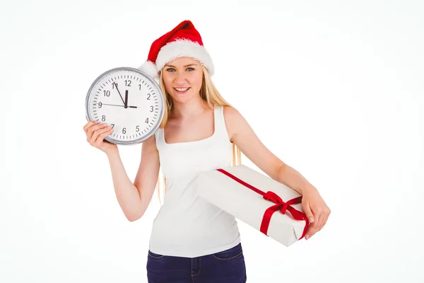 Festive blonde holding a clock and gift — Stock Photo, Image