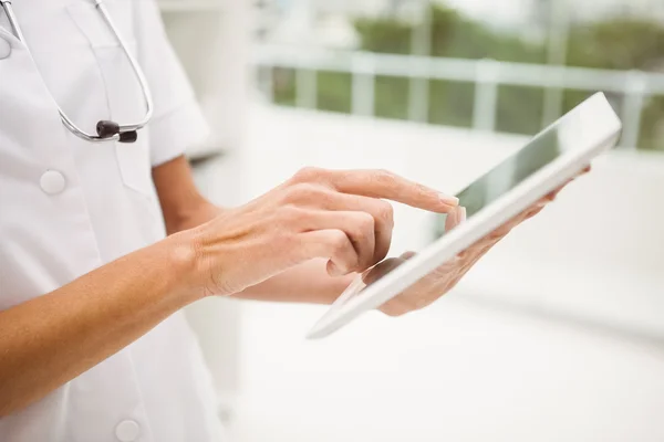 Mid section of female doctor using digital tablet in medical office — Stock Photo, Image