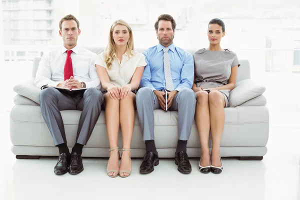 Businessman against people waiting for interview — Stock Photo, Image