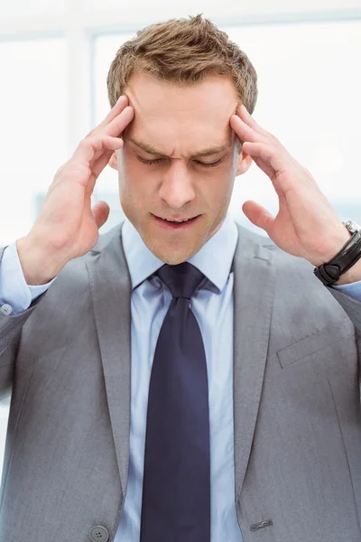 Empresário com dor de cabeça severa no escritório — Fotografia de Stock