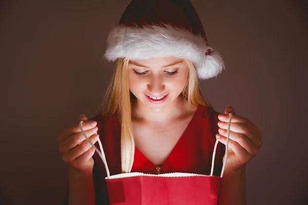 Loira festiva abrindo um saco de presente — Fotografia de Stock