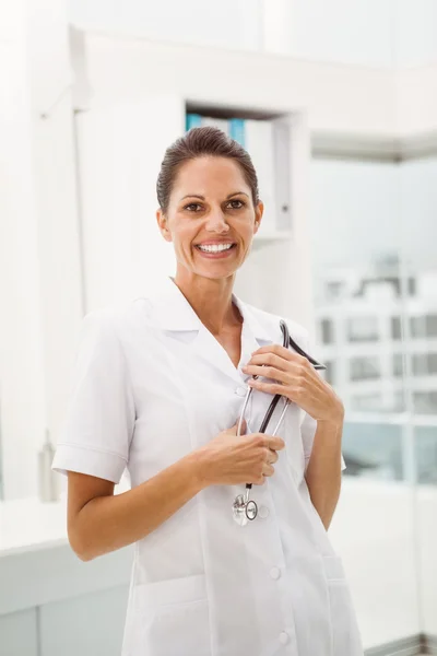 Médico sonriente con estetoscopio en consultorio médico —  Fotos de Stock