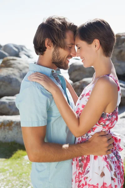 Gorgeous couple embracing by the coast — Stock Photo, Image