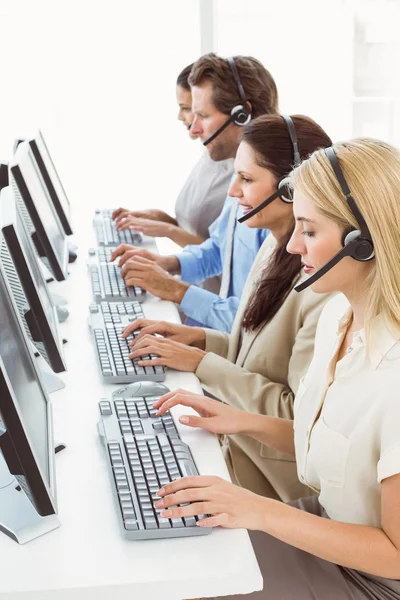 Gente de negocios con auriculares usando computadoras en la oficina —  Fotos de Stock