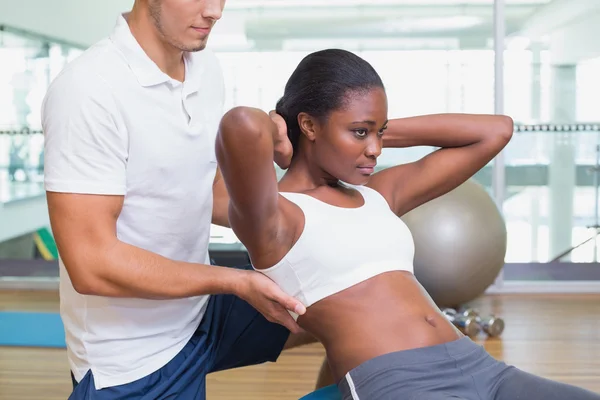 Personal trainer working with client on exercise ball — Stock Photo, Image