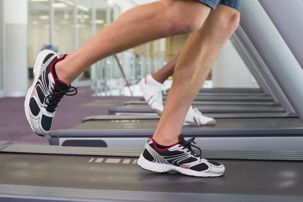 Fit man and woman running on treadmill — Stock Photo, Image