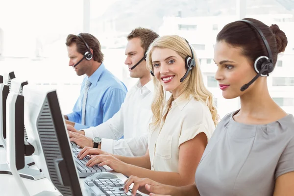 Gente de negocios con auriculares usando computadoras en la oficina —  Fotos de Stock