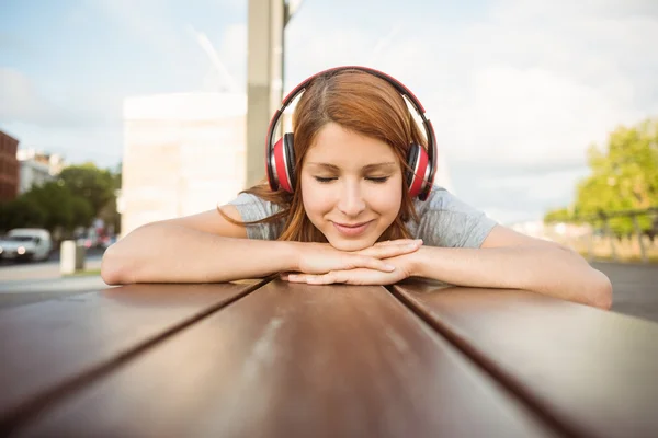 Kvinna lyssna med hörlurar till musik med slutna ögon — Stockfoto