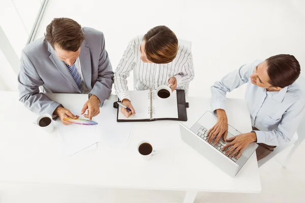 Uomini d'affari con computer portatile e diario in ufficio — Foto Stock