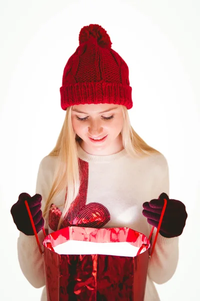 Праздничная блондинка открывает подарочный пакет — стоковое фото