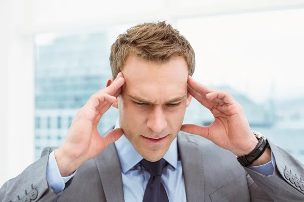 Businessman with severe headache at office — Stock Photo, Image