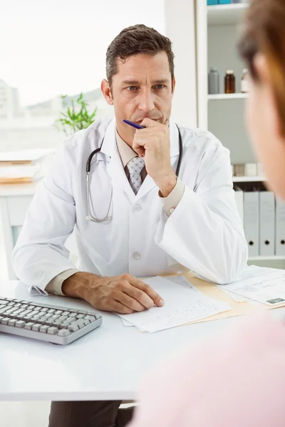 Läkare i diskussion med patienten vid skrivbord — Stockfoto