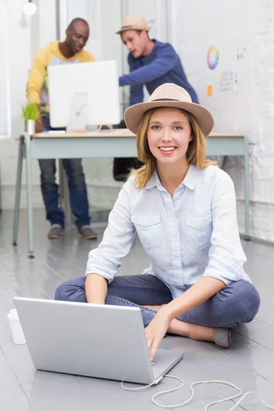 Casual man använder laptop med kollegor bakom i office — Stockfoto