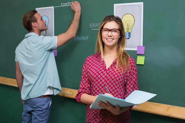 Creative business people at work against blackboard — Stock Photo, Image