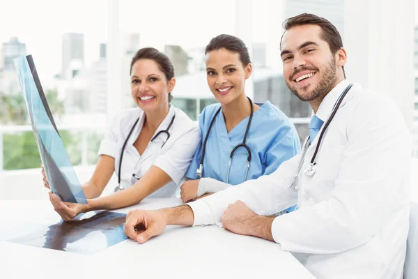 Male and female doctors examining x-ray — Stock Photo, Image