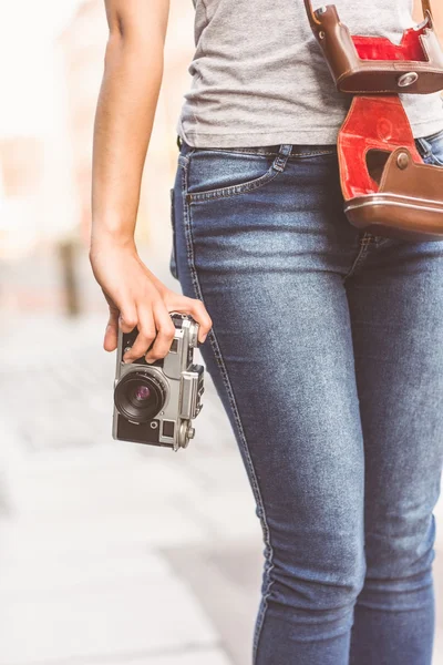 Acercamiento de una chica vistiendo jeans y sosteniendo una cámara — Foto de Stock