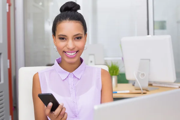 Businesswoman text messaging at office desk — Stock Photo, Image