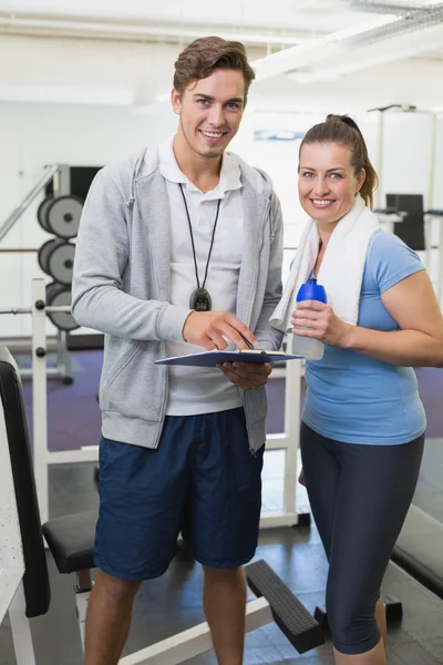 Entraîneur personnel et client souriant à la caméra — Photo