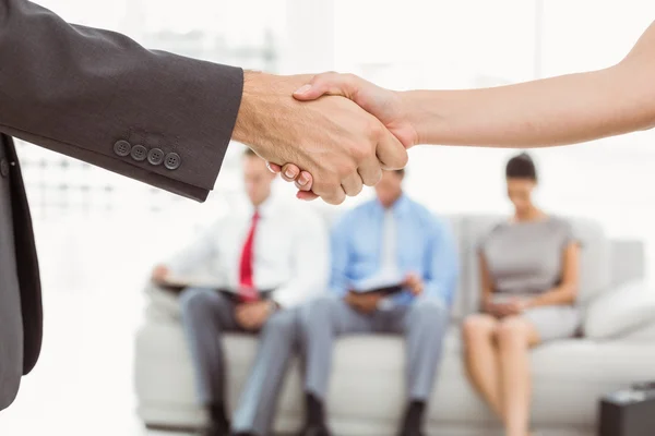 Handshake além de pessoas à espera de entrevista — Fotografia de Stock