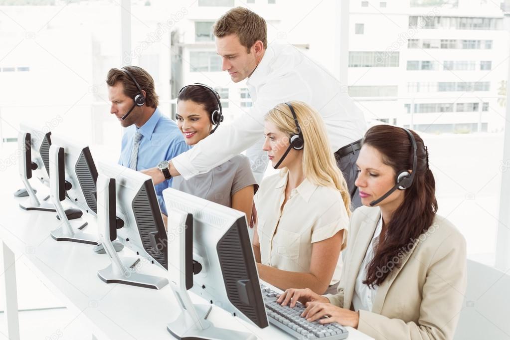 Business people with headsets using computers in office — Stock Photo