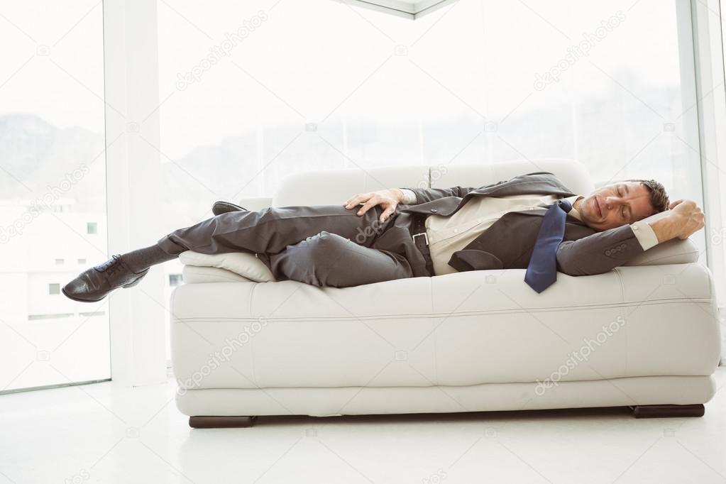 Hombre durmiendo en el sofá en la sala de negocios — Foto de stock