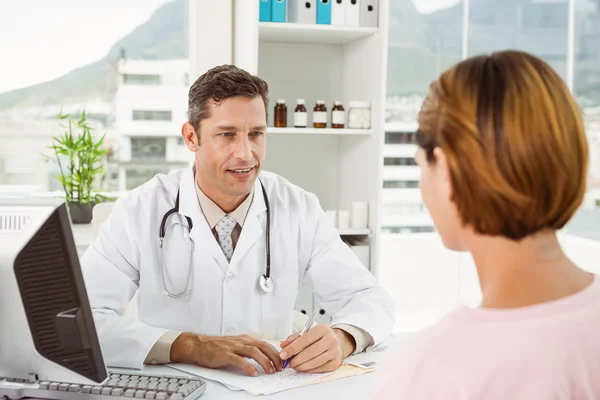 Läkare och patient i diskussion på läkarmottagning — Stockfoto