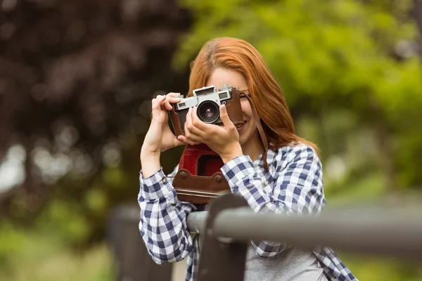 Pretty redhead taking a picture with retro camera — Stock Photo, Image