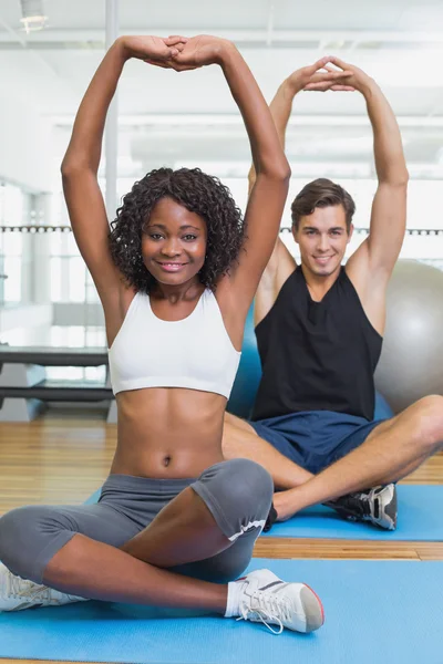 Fit casal aquecimento em tapetes de exercício — Fotografia de Stock