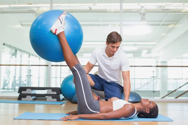 Treinador pessoal trabalhando com o cliente segurando bola de exercício — Fotografia de Stock