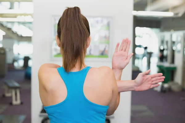 Fit brunette warming up in fitness studio — Stock Photo, Image