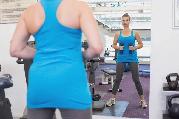 Fitte Brünette trainiert mit Kurzhanteln — Stockfoto