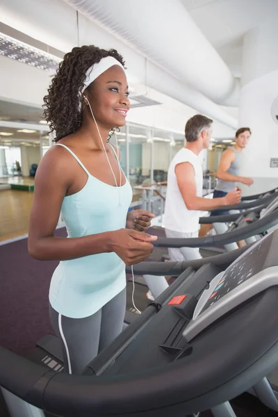 Fit woman on treadmill listening to music — Stock Photo, Image